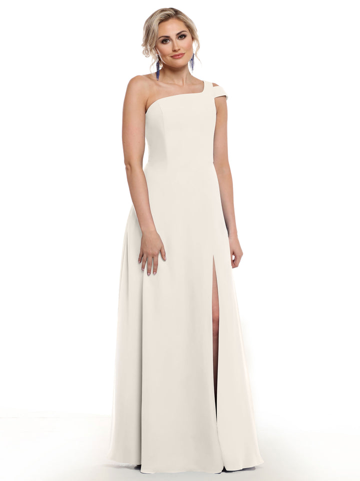A woman in Avery Austin’s off-white one-shoulder dress (style 80139) with a thigh-high slit stands against a white background, her light hair styled up as she looks at the camera.