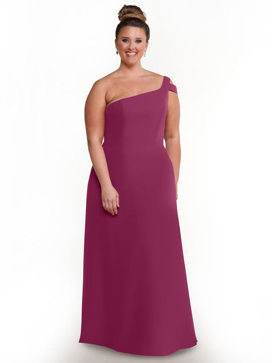 A woman smiles in the Avery Austin TH-80139, a sleeveless floor-length plum one-shoulder dress with an asymmetric neckline, radiating elegance and sophistication against a white background.
