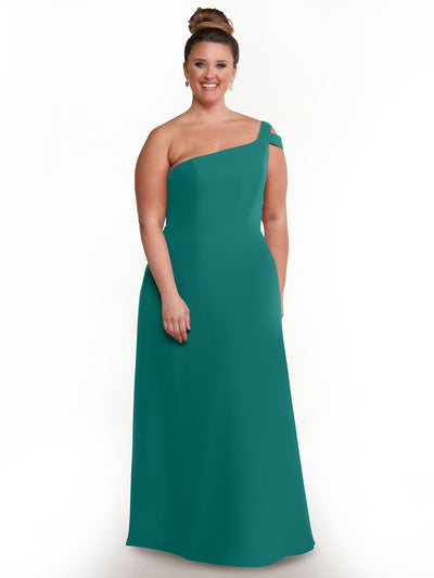 Wearing Avery Austin’s 80139, a teal one-shoulder, floor-length gown with an elegant side slit, a woman stands smiling against a plain white background. Her hair is in a high bun and she accessorizes with earrings.