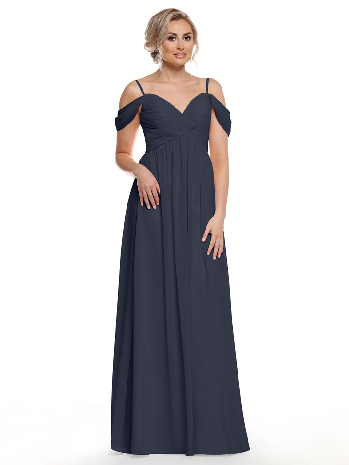 A woman wearing Avery Austin dress 80142—a long navy blue chiffon gown with thin straps and a sweetheart neckline—stands against a plain white background.