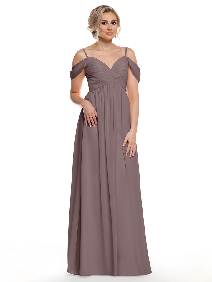 A woman stands against a white background in the Avery Austin 80142—a mauve, floor-length chiffon dress with thin straps and a sweetheart neckline. Her blonde hair is styled up and she accessorizes with earrings for subtle boho chic elegance.