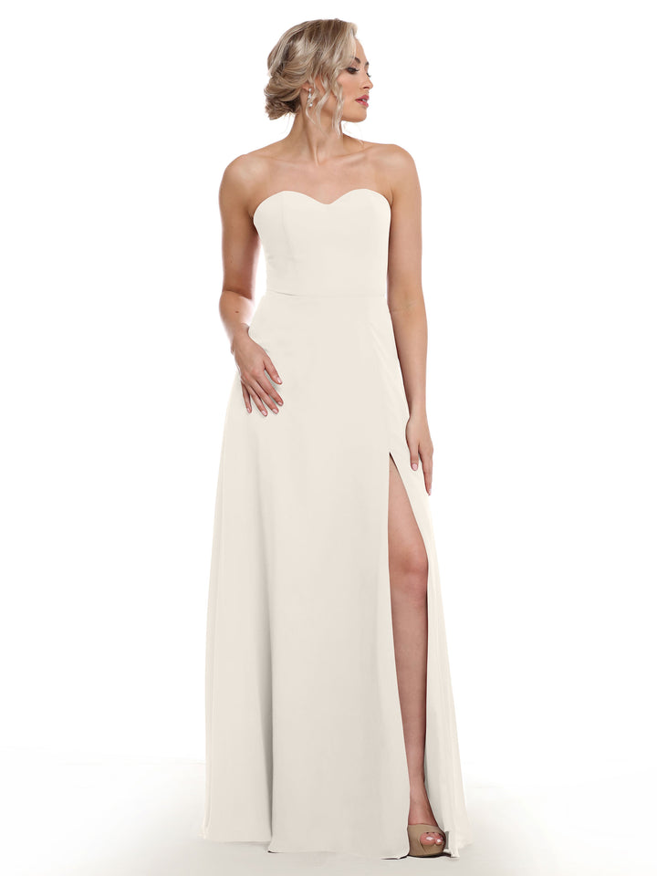 A woman models the Avery Austin 80143 strapless sweetheart dress with a sash back, floor-length skirt, and high side slit against a plain white background.