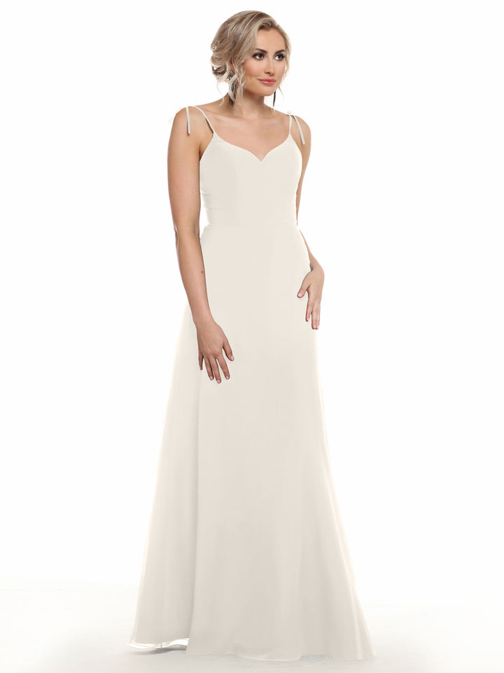 A woman with blonde hair in an updo models the Avery Austin 80144: a long, sleeveless white chiffon dress with thin straps and a fitted V-neck bodice. She stands against a plain white background, gazing slightly to the side.