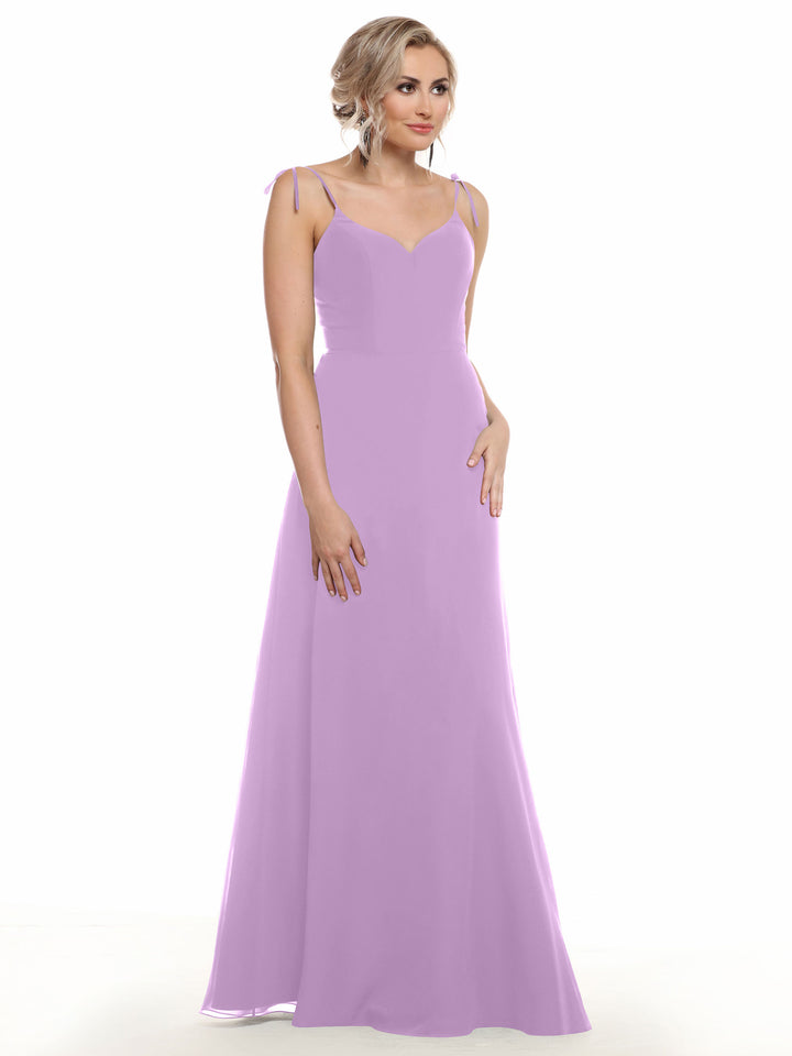 A woman models Avery Austin’s 80144, a long sleeveless lavender chiffon dress with thin straps, a fitted bodice, and V-neckline, standing against a plain white background.
