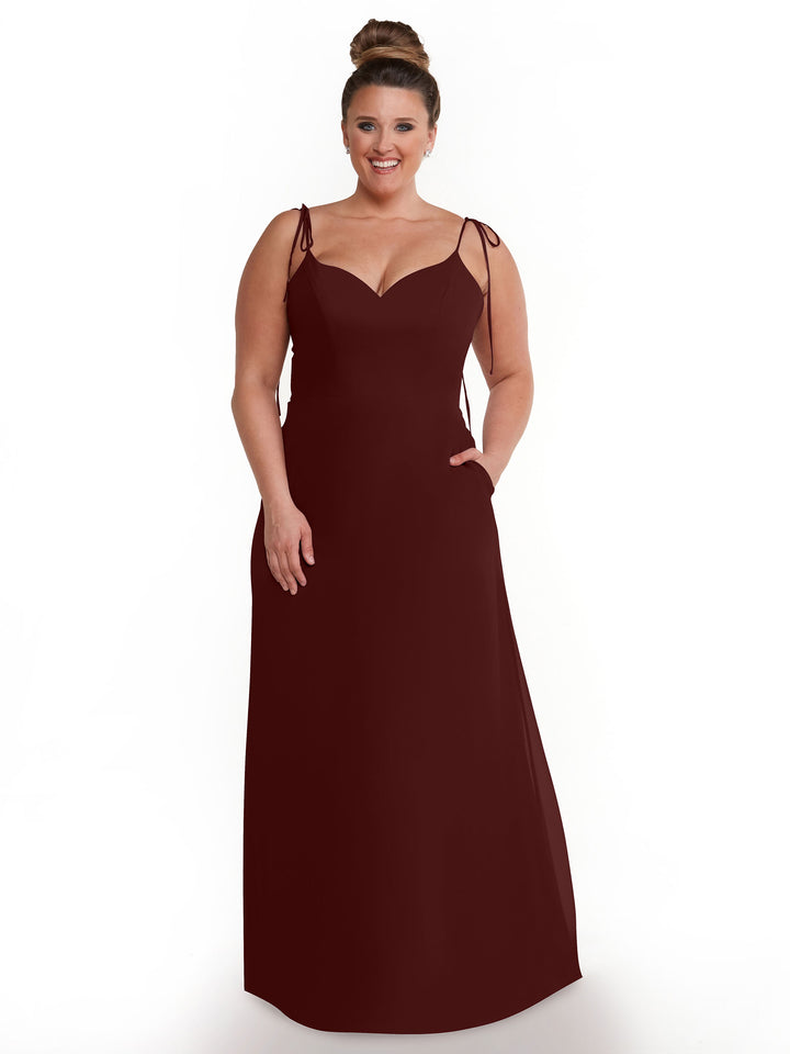 A woman smiles with her hand in her pocket, wearing Avery Austin&