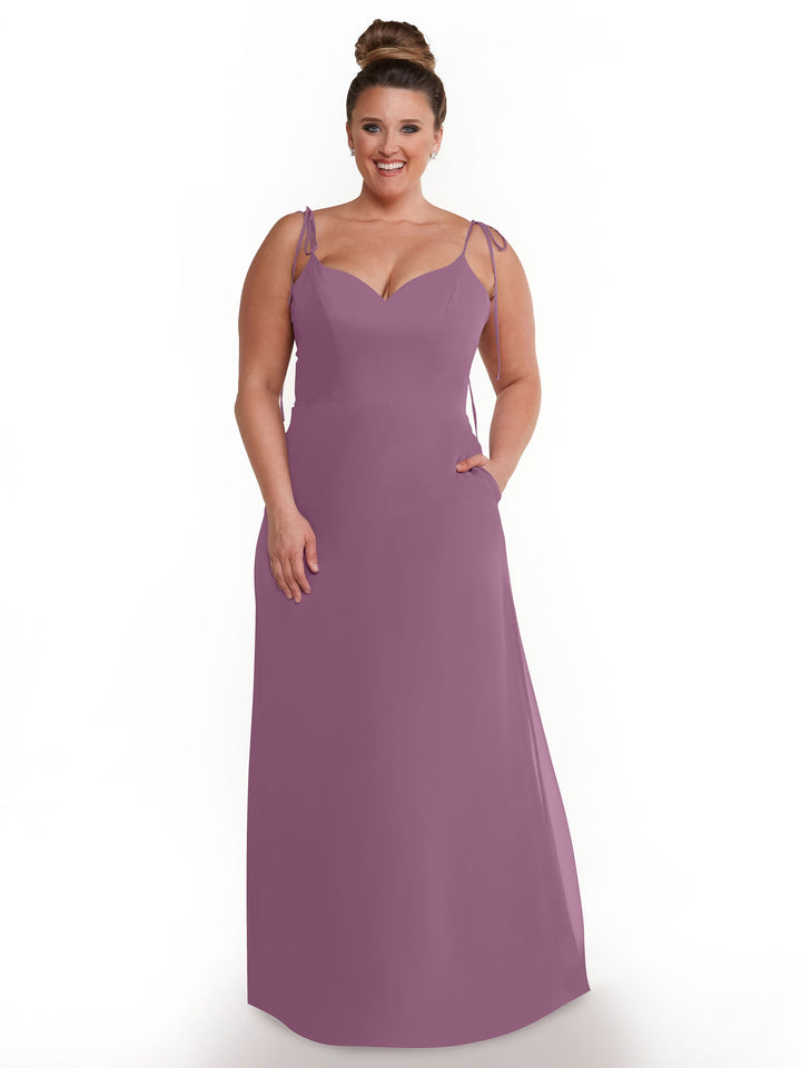 A smiling woman stands against a white background wearing Avery Austin&