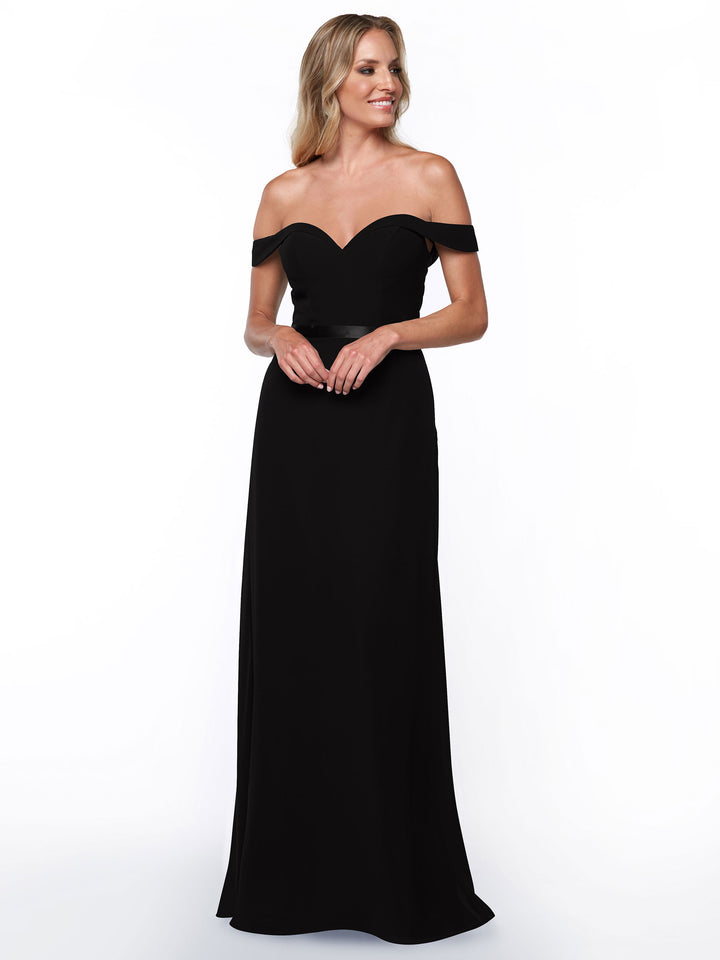A woman in the Avery Austin 80145 long, off-the-shoulder bridesmaid dress stands against a plain white background, smiling and looking slightly to the side.
