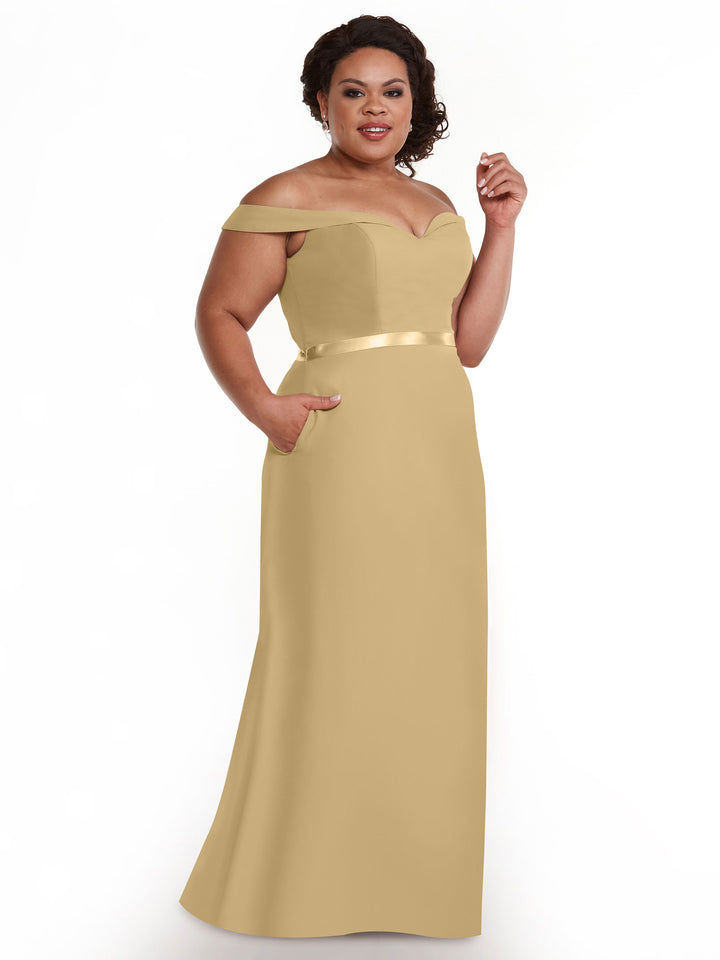 A woman smiles against a white background, wearing Avery Austin&