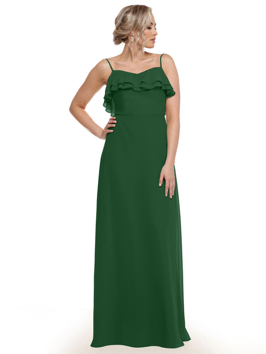 A woman models Avery Austin's 80146: a sleeveless, floor-length dark green chiffon A-line dress with thin straps and tiered ruffles across the chest, standing against a white background with her hand on her hip.