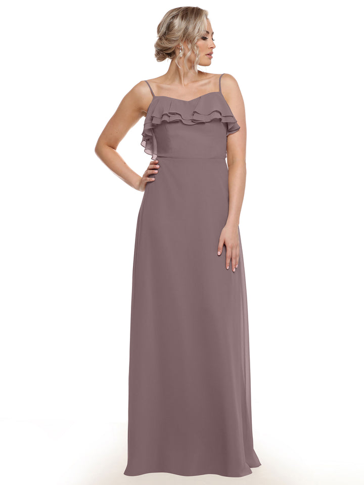 A model poses with her hand on her hip, showcasing the Avery Austin 80146—a floor-length mauve chiffon A-line dress with thin straps and tiered chest ruffles—against a white background.