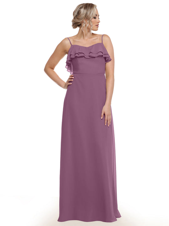 A woman with blonde hair in an updo models Avery Austin style 80146—a sleeveless, floor-length mauve chiffon A-line dress with thin straps and a tiered ruffled neckline—against a plain white background.