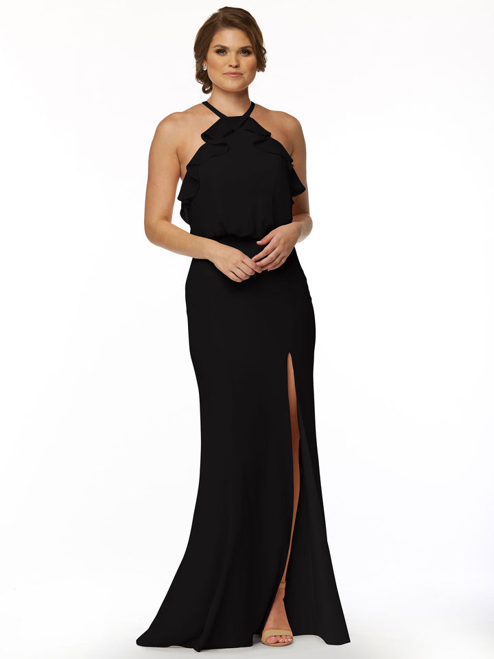 A woman with short brown hair wears Avery Austin 80147—a sleeveless, floor-length fitted chiffon dress with a ruffled halter neckline and front leg slit—paired with open-toed beige heels against a white background.