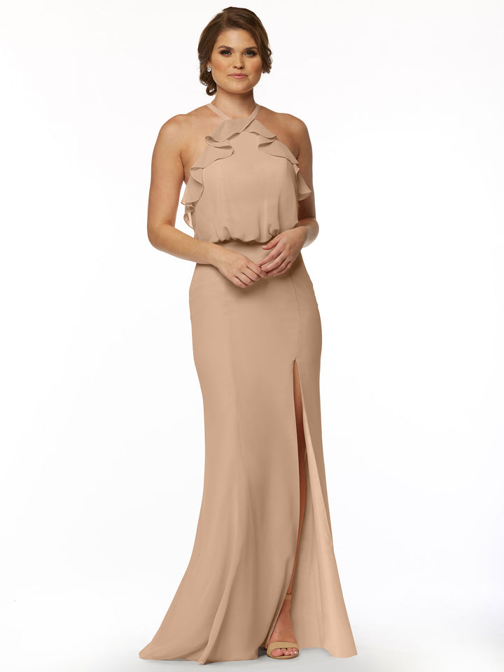 A woman models Avery Austin’s 80147: a fitted blush chiffon dress with a ruffled halter top and thigh-high side slit, set against a plain white background.