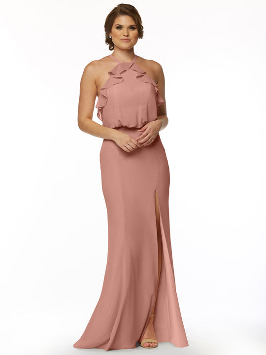 A woman in Avery Austin’s 80147 fitted chiffon dress, featuring a ruffled halter top and front slit, poses against a white background. She has short hair and finishes the look with open-toed heels.