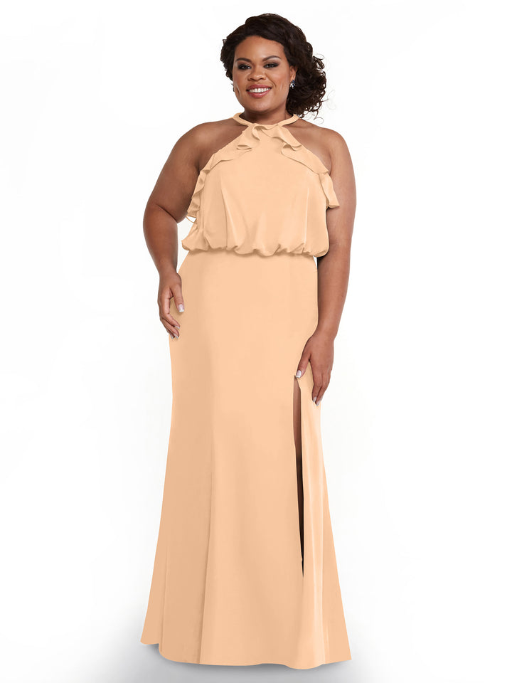 A woman stands and smiles against a white background, wearing Avery Austin’s fitted chiffon dress, style 80147, featuring a ruffled halter top and thigh-high side slit.