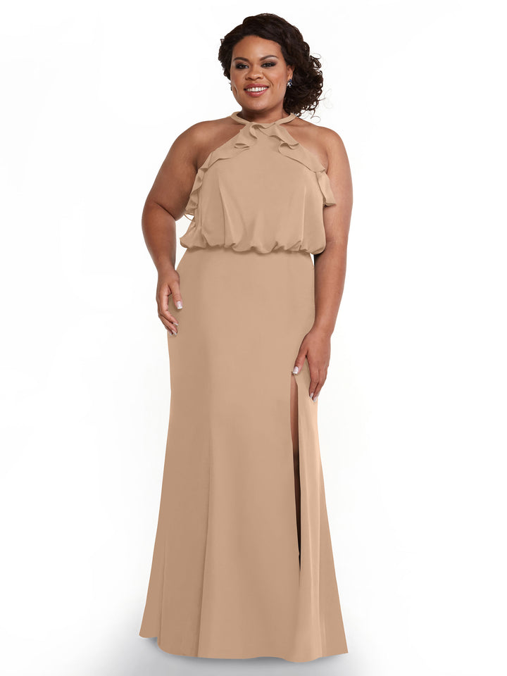 A woman models Avery Austin’s 80147: a sleeveless tan floor-length dress with a side slit and ruffled neckline, standing and smiling against a plain white background.