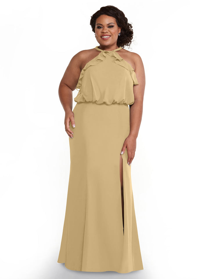 A woman smiles in Avery Austin’s 80147: a sleeveless light gold dress with a ruffled halter top, side slit, and floor-length chiffon. Her curly dark hair is styled to the side, enhancing her elegant look.
