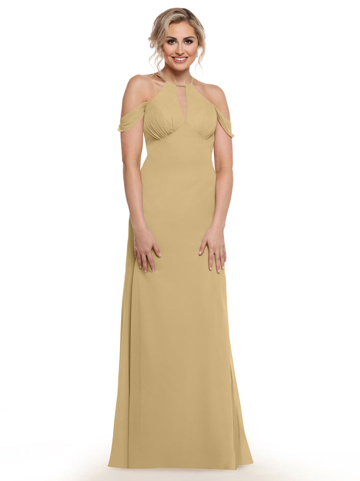A woman smiles against a white background wearing Avery Austin’s 80148—a long, light gold off-the-shoulder dress with chiffon cap sleeves and a halter neckline.