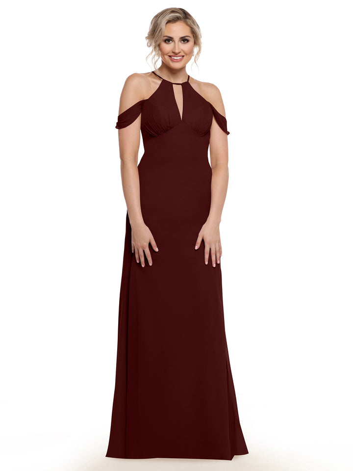 A woman smiles against a white background wearing Avery Austin’s 80148, a floor-length burgundy halter dress with a keyhole detail.