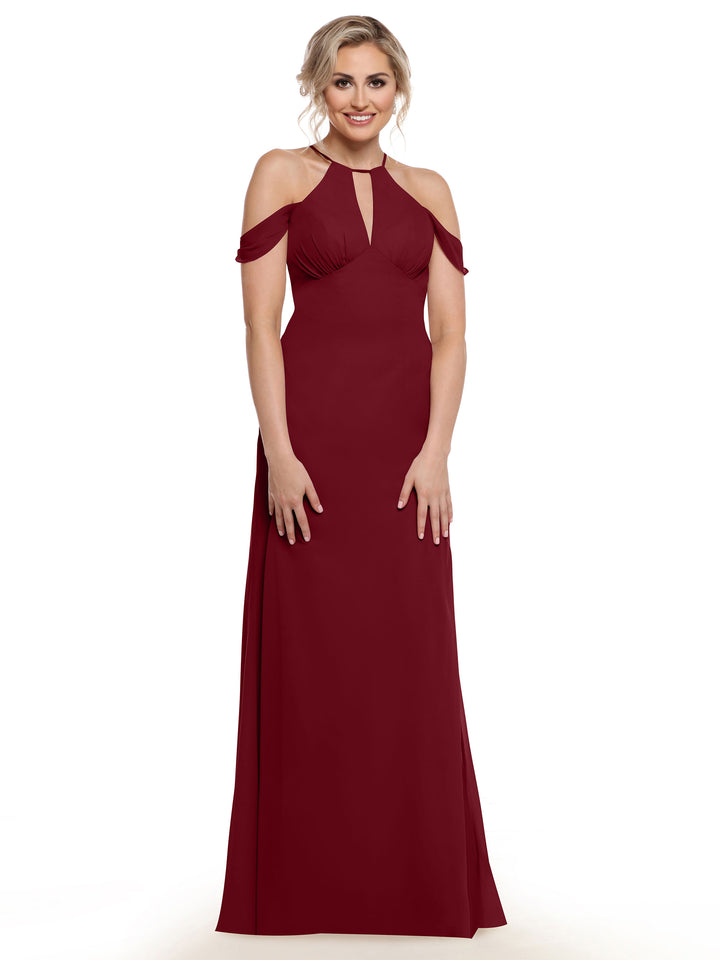 A woman smiles against a white background wearing the Avery Austin TH-80148, a floor-length burgundy gown with sleeveless cold shoulder straps and a keyhole neckline, styled in elegant chiffon.