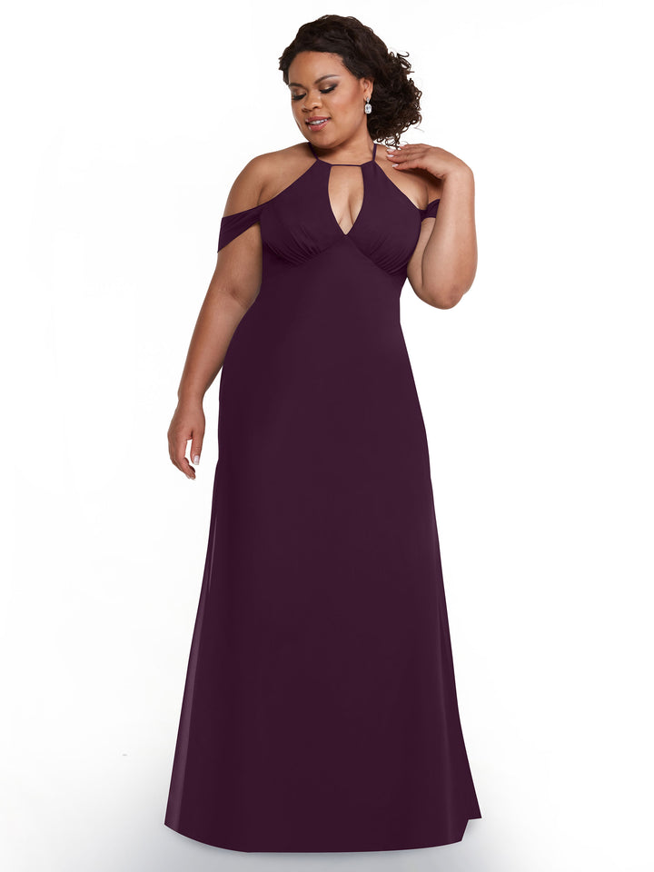 A woman models Avery Austin’s 80148 dress—a floor-length, deep purple, off-the-shoulder gown with chiffon cap sleeves—standing against a white background, gently touching her neck and smiling softly.