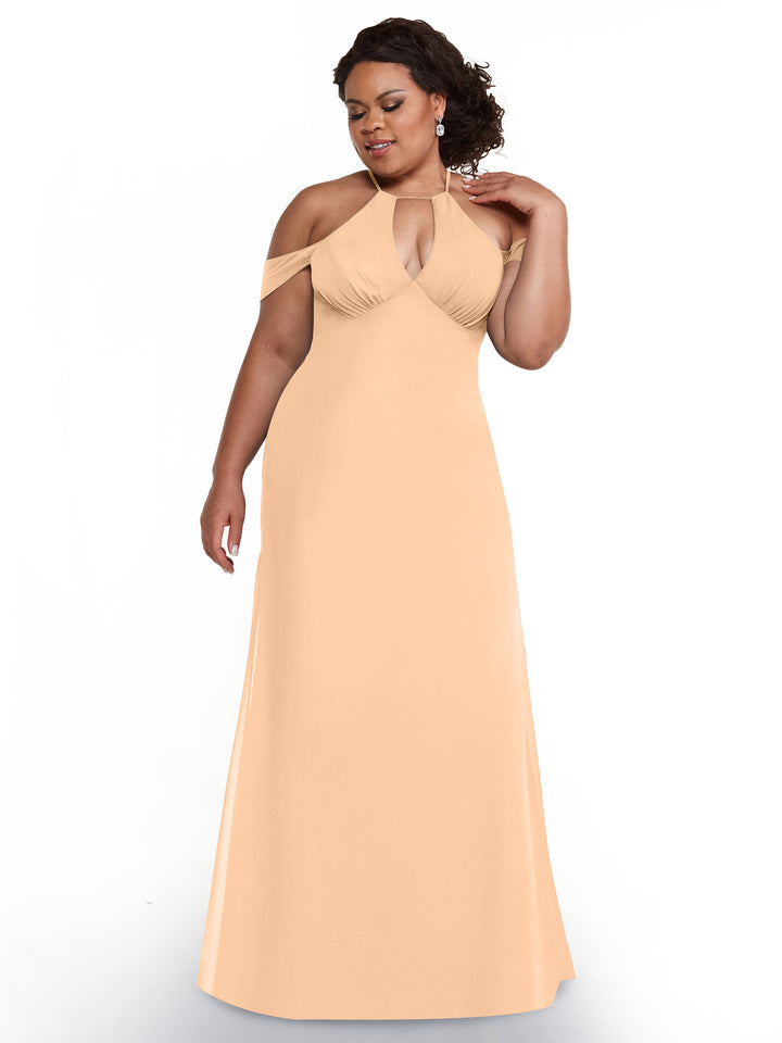 A woman models Avery Austin’s 80148, a peach off-the-shoulder dress with chiffon cap sleeves and halter neckline, posing against a white background with one hand raised to her shoulder and gazing slightly downward.