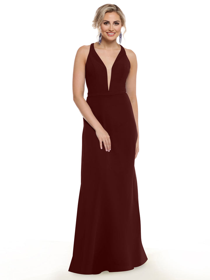 A woman with light hair styled up and statement earrings smiles against a white background, wearing Avery Austin’s 80150: a floor-length burgundy gown featuring an electrifying design and deep V-neck.