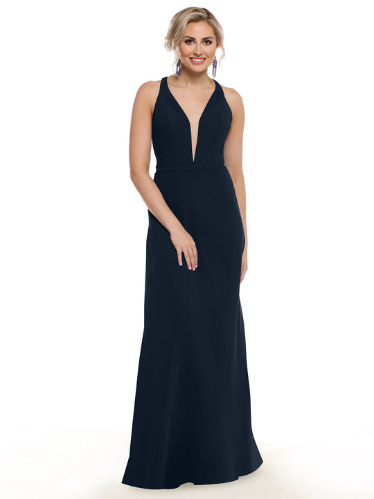 A woman with blonde hair styled up and statement earrings smiles against a white background, wearing Avery Austin’s 80150—a sleeveless, floor-length black gown with geometric cut-outs and a deep V-neckline.