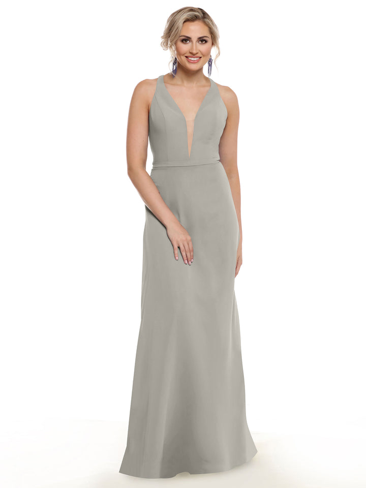 A woman stands smiling against a plain white background, wearing Avery Austin&