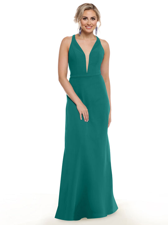 A woman with light hair in an updo and earrings stands smiling against a white background, showcasing Avery Austin's 80150—an electrifying, floor-length teal gown featuring a plunging neckline.