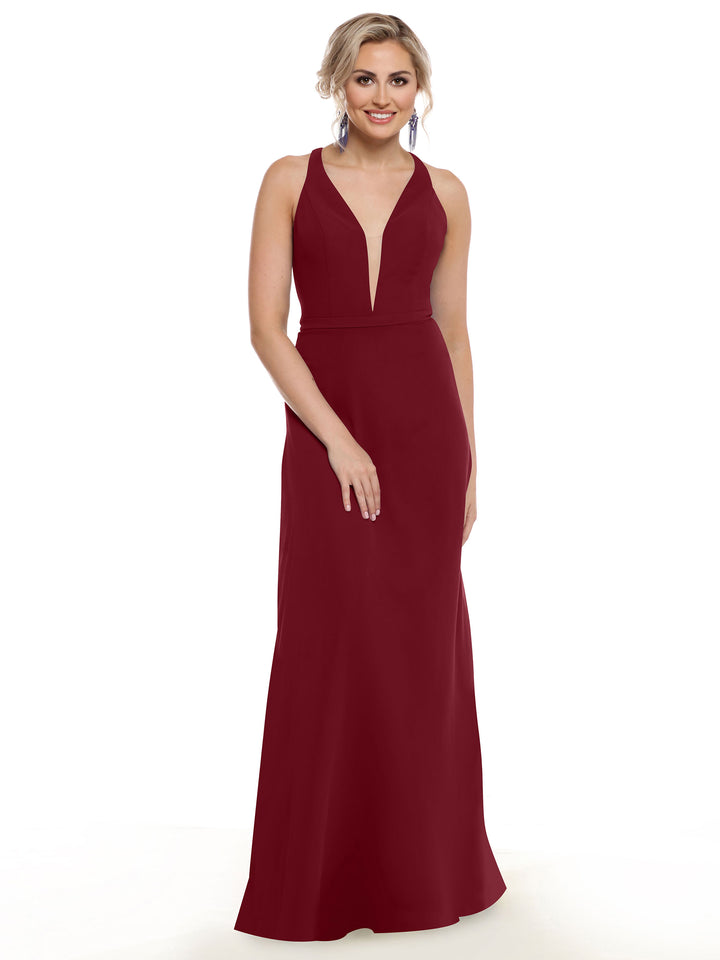 A woman poses against a white background in Avery Austin’s 80150—a sleeveless, floor-length deep burgundy gown with a plunging V-neckline. Her light hair is styled up and she accessorizes with bold drop earrings.