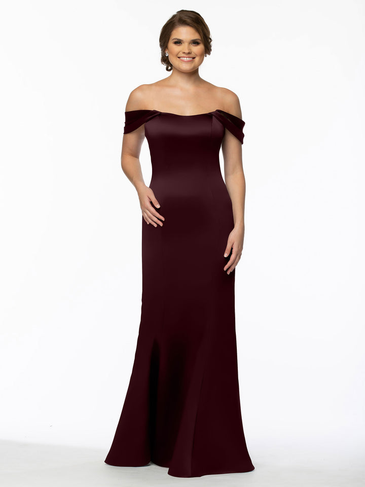 A woman smiles with her hair styled back, posing against a white background in the Avery Austin 80151—a chic off-the-shoulder dress featuring convertible straps.