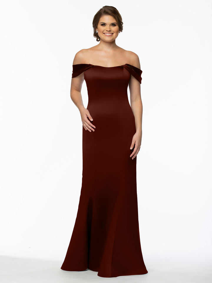 A woman models the Avery Austin 80151, a floor-length, off-the-shoulder dress with convertible straps. The fitted gown hugs her bodice and hips before gently flaring at the bottom, showcased against a plain white background.
