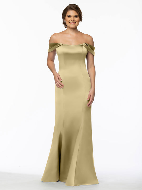 A woman in a fitted, off-the-shoulder, floor-length Avery Austin dress (TH-80151) in Palomino smiles against a plain white background.