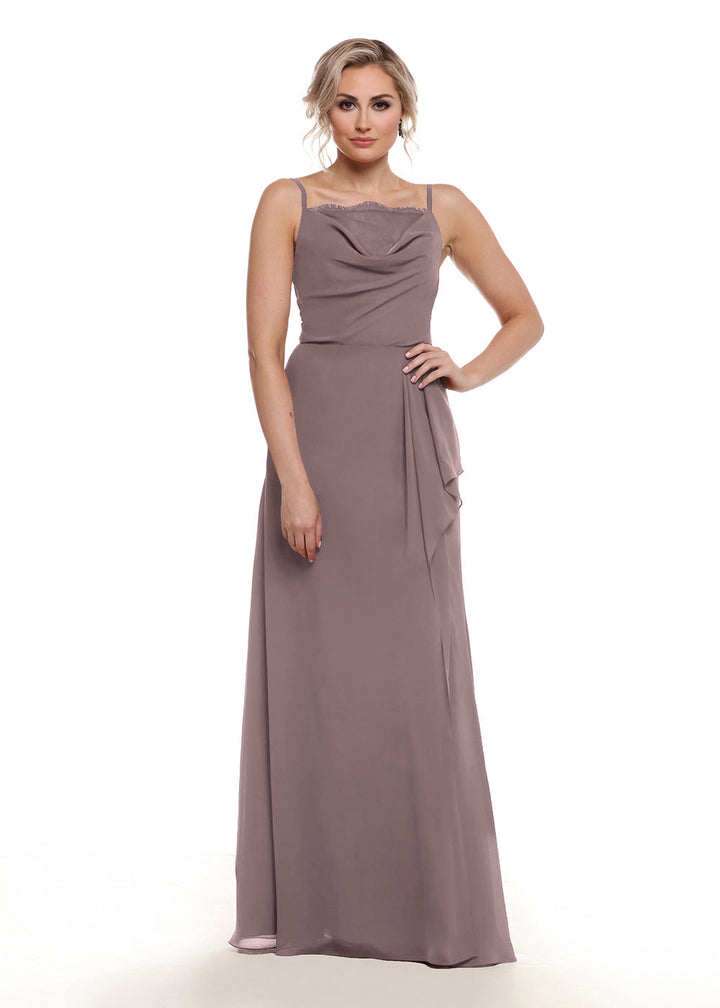 A woman stands facing forward with one hand on her hip, modeling Avery Austin style 80152: a mauve, floor-length chiffon A-line dress with thin straps, draped neckline, side slit, and side sash against a plain white background.