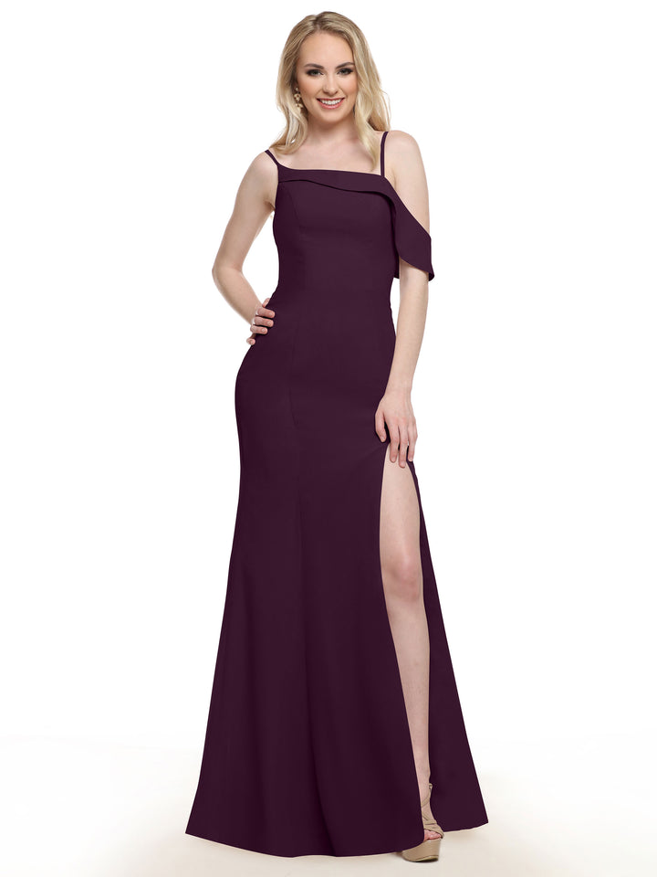 A woman wearing Avery Austin’s 80153, a sleeveless dark purple chiffon bridesmaid dress with a thigh-high slit, stands smiling with one hand on her hip against a plain white background.