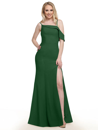A woman poses with a smile and one hand on her hip in the Avery Austin 80153 floor-length, hunter green high-slit dress, set against a plain white background.