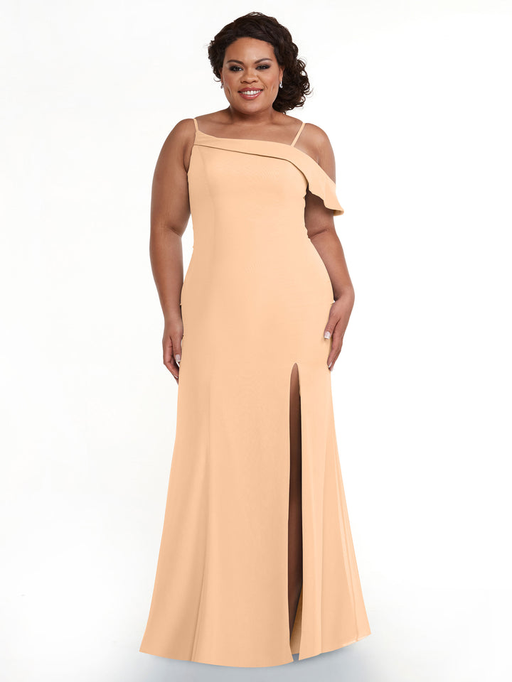 A woman wearing Avery Austin’s 80153, a long peach one-sleeve bridesmaid dress with an asymmetric neckline, ruffle detail, and front slit, smiles against a white background.