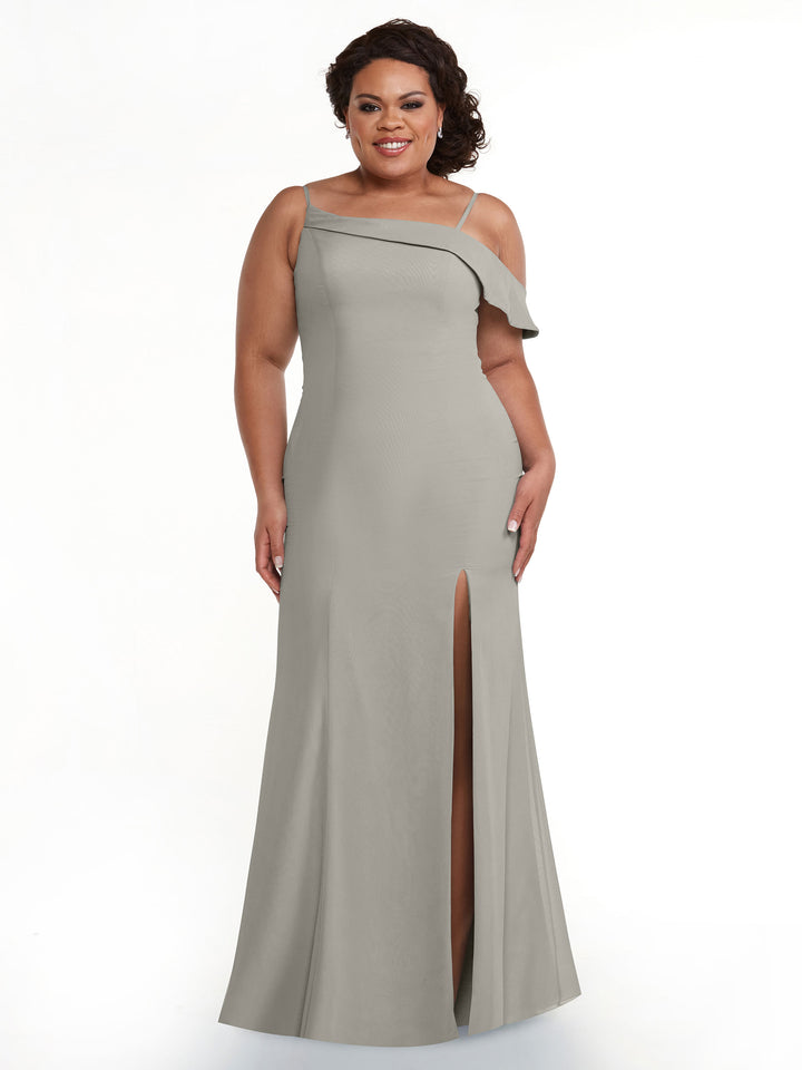 A woman smiles in front of a white background, wearing Avery Austin style 80153—a light grey, floor-length chiffon bridesmaid dress with a thigh-high slit, one-shoulder strap, and ruffle detail.
