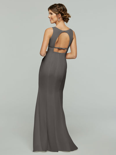 A woman models Avery Austin’s 80155: a sleeveless, floor-length gray gown with an open keyhole back and cutout, posing against a plain light background.