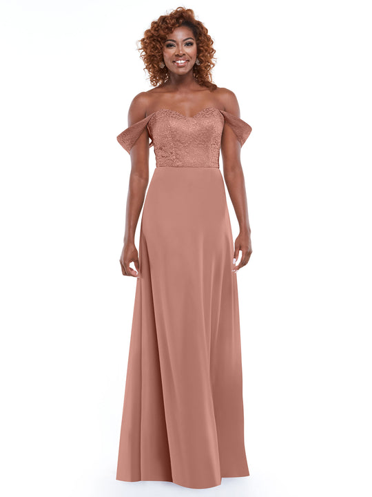 A woman smiles in front of a white background, wearing Avery Austin style 80164—a dusty rose off-the-shoulder dress with a lace bodice and flowing chiffon skirt.