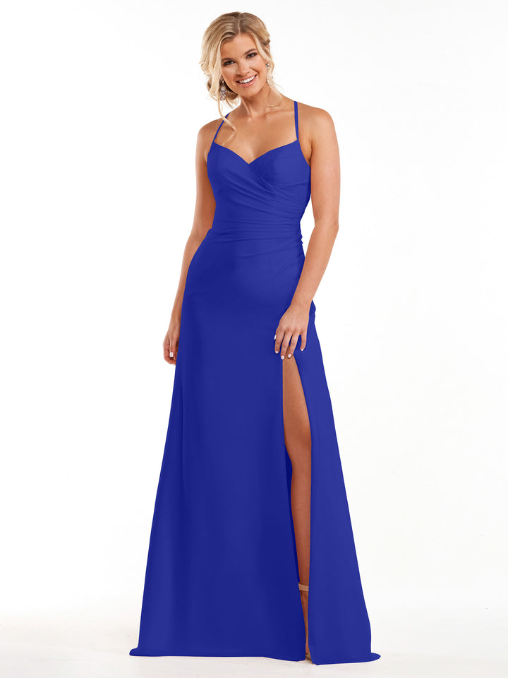 A woman in the Avery Austin 80167, a cobalt floor-length chiffon bridesmaid dress with thin straps, sweetheart neckline, ruched bodice, and high slit, stands smiling against a white background.