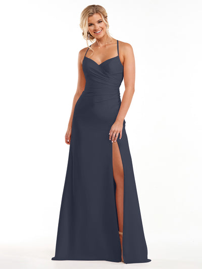 A woman in Avery Austin’s indigo chiffon dress (style 80167) with a sweetheart neckline, spaghetti straps, and a thigh-high slit smiles against a plain white background.