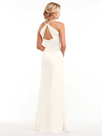 A woman with blonde hair in a low updo wears Avery Austin’s 80167, an ivory chiffon gown with a halter neckline, keyhole back, and subtly ruched bodice. She stands facing away, showcasing the dress’s floor-length elegance.