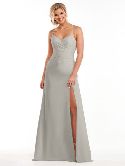 A woman smiles against a white background, wearing Avery Austin's silver chiffon dress (Style 80167) featuring spaghetti straps, a sweetheart neckline, ruched bodice, and a high side slit.