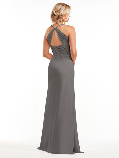 A woman with blonde hair in an updo models Avery Austin’s 80167—a long, dark gray chiffon dress with spaghetti straps and a gathered, crisscross back featuring a keyhole detail—against a plain white background.