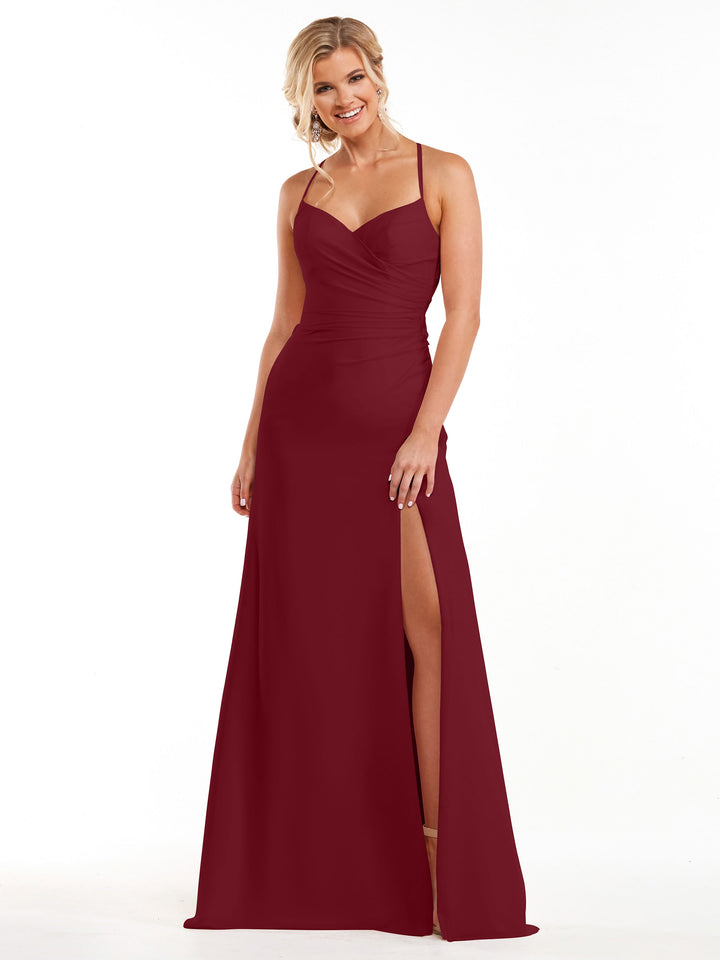 A woman wearing Avery Austin style 80167, a sleeveless floor-length burgundy a-line bridesmaid dress with thin straps and a thigh-high slit, smiles against a plain white background.