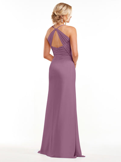 Avery Austin style 80167: Woman in a mauve, floor-length chiffon halter dress with open back stands against a plain white background, facing away from the camera.