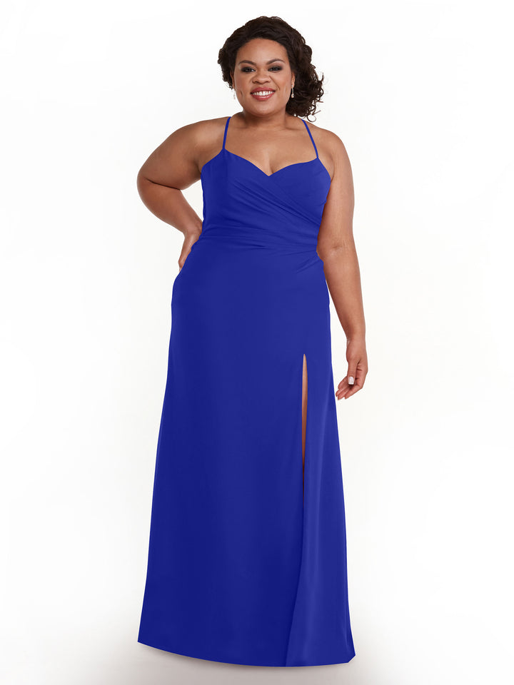 A woman smiles against a white background wearing Avery Austin style 80167, an A-line bridesmaid dress in cobalt with a sweetheart neckline and thigh-high slit.