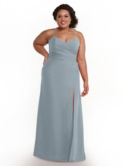 A woman smiles against a white background wearing Avery Austin 80167—a dusty blue, floor-length chiffon dress with spaghetti straps and a thigh-high slit.